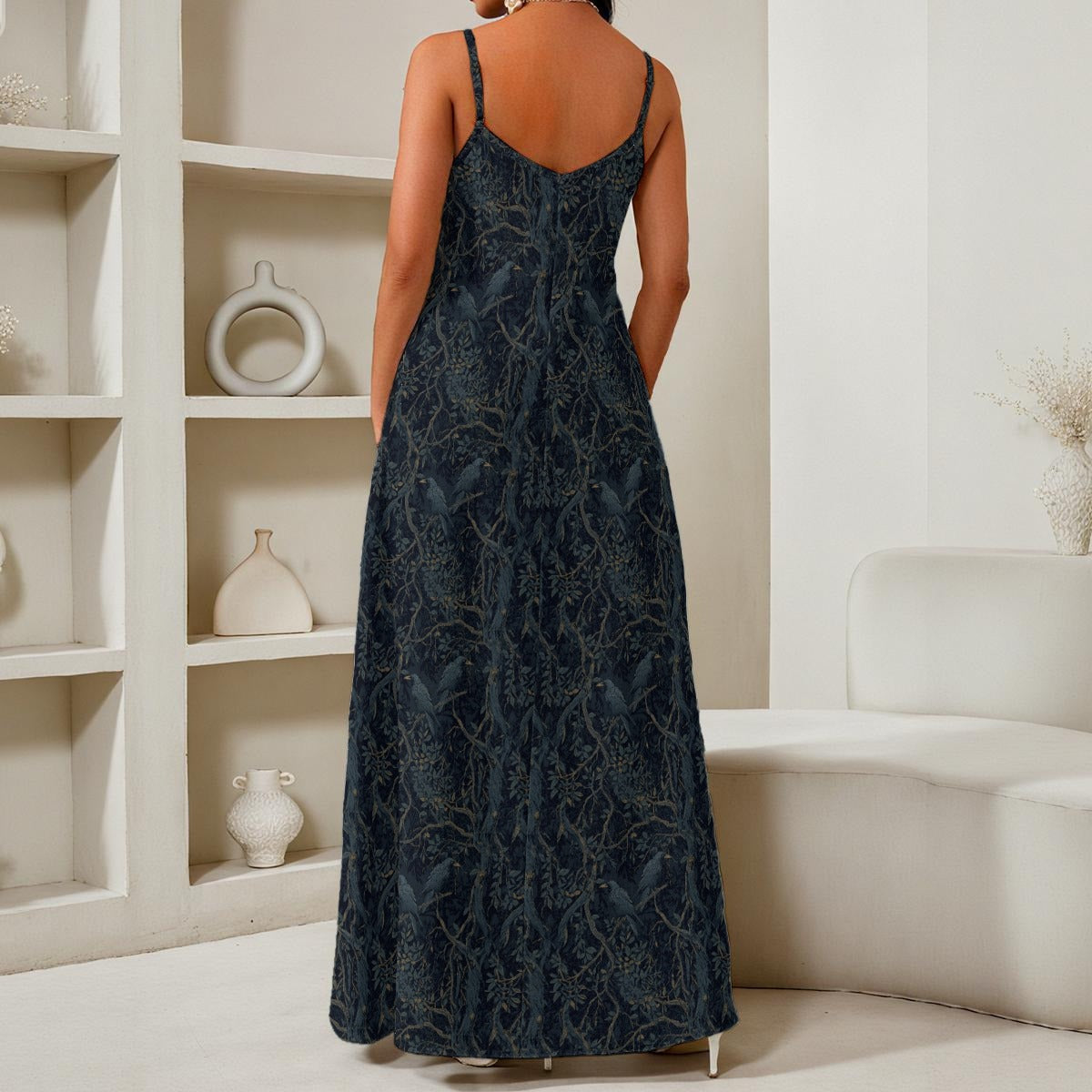 Woman wearing a dark blue patterned dress in a room with white shelves and furniture.