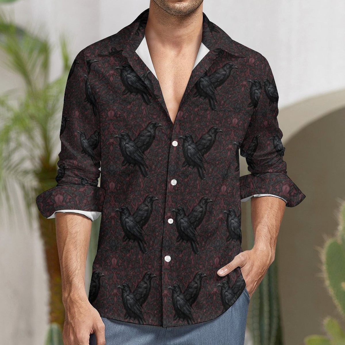 Man wearing a dark patterned shirt with black birds in an outdoor setting