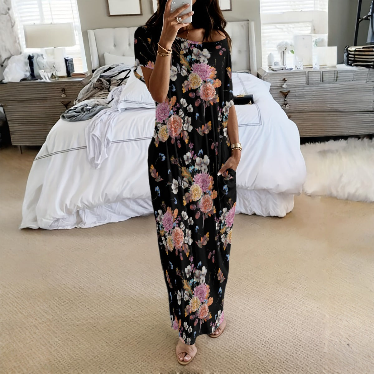 Woman taking a mirror selfie wearing a floral dress in a bedroom.