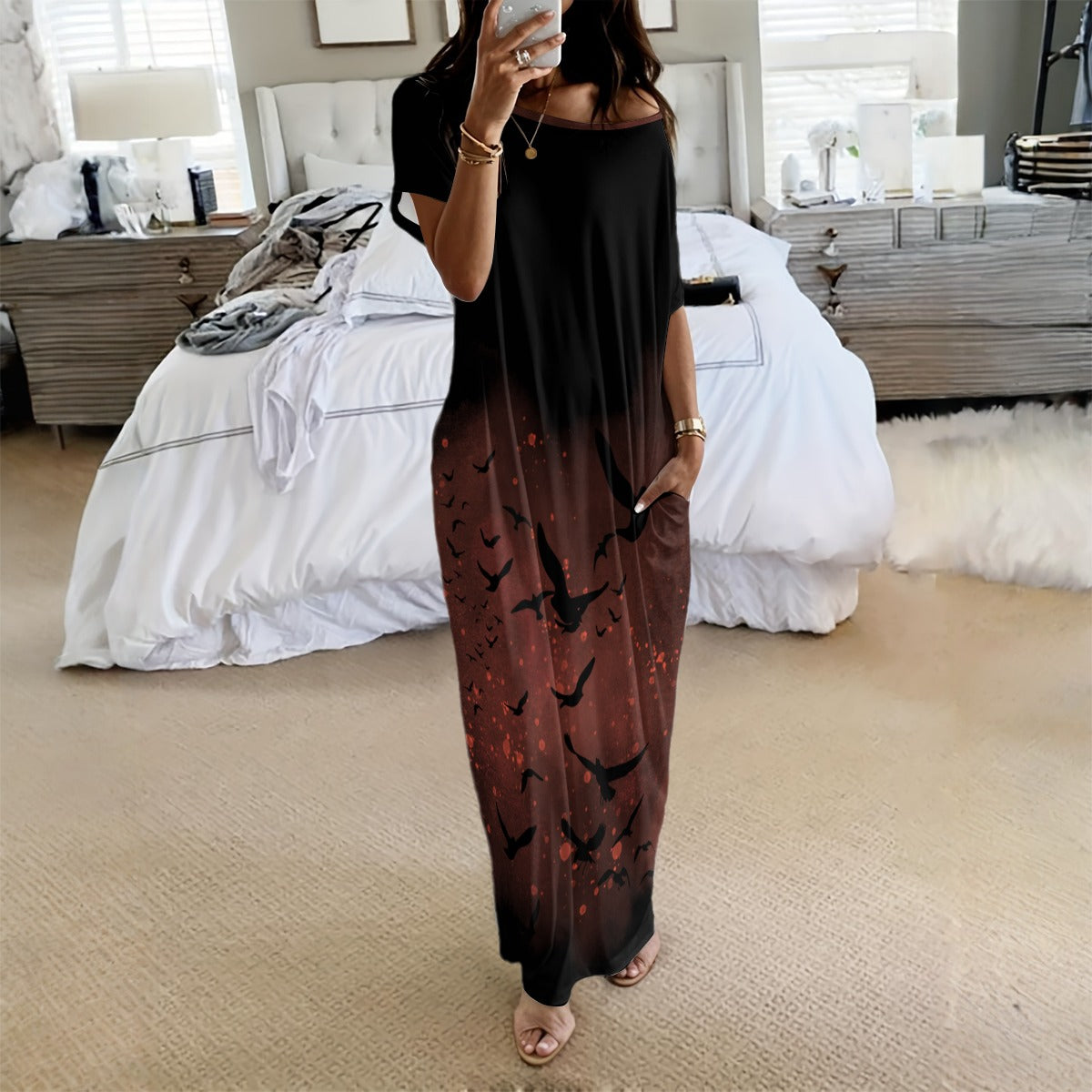 Woman taking a mirror selfie wearing a black and brown dress with bird pattern in a bedroom.